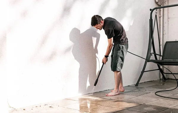 man cleaning the corners using a pressure washing