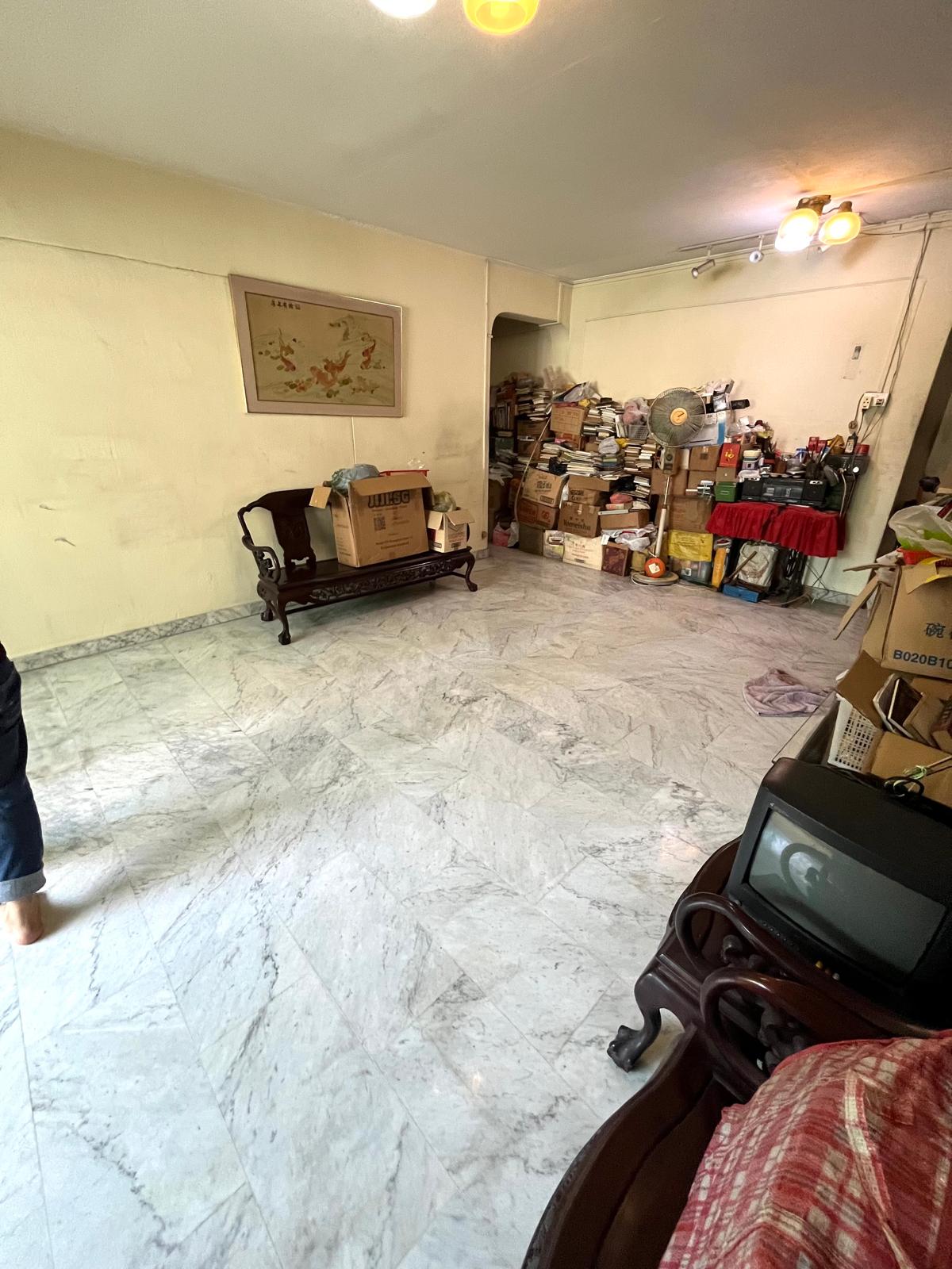 The same living area after decluttering, with a clear walkway and organised bookshelf