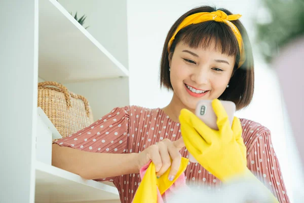 Close-up of a woman smiling and using a smartphone.