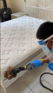 man cleaning side of bed 