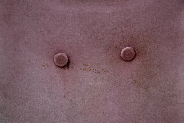 Pink upholstery, dirty and faded, with two buttons on the chair as a background