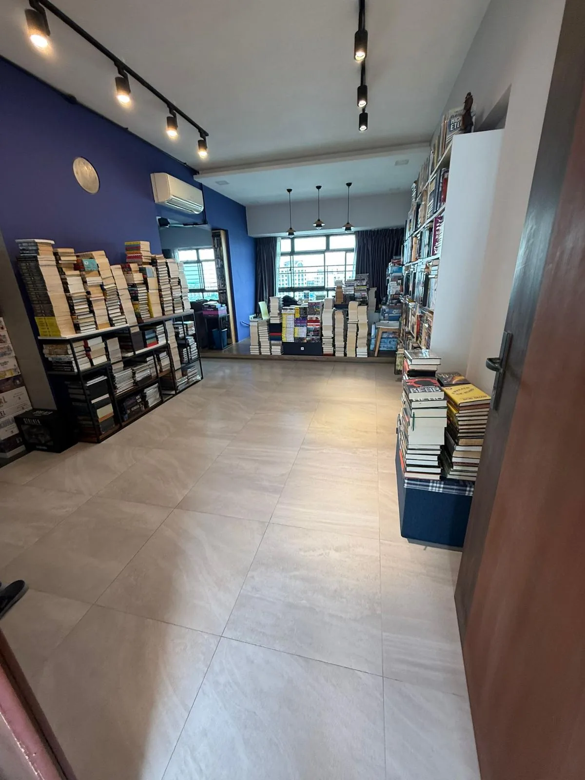 The same living area after decluttering, with a clear walkway and organised bookshelf