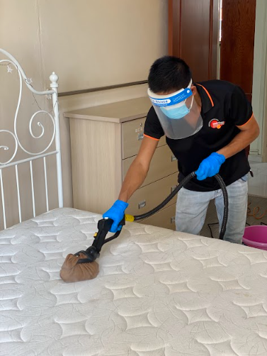 worker cleaning bed