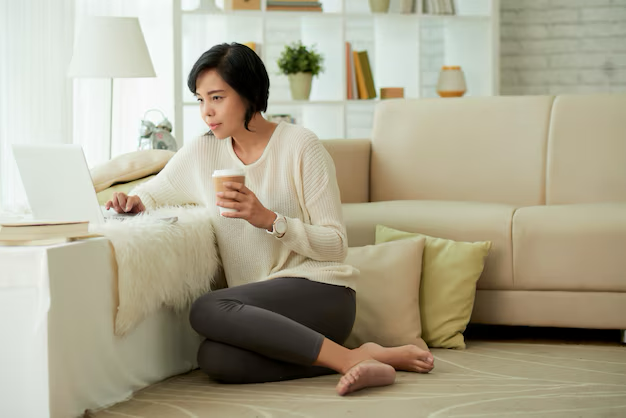 Asian woman enjoying home comforts in a living room background.